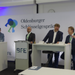 Podiumsdiskussion der „Oldenburger Schlüsselgespräche“ im Bundestechnologiezentrum für Elektro- und Informationstechnik (BFE). Fünf Referenten und ein Moderator sitzen auf einer Bühne an Stehtischen und diskutieren.
