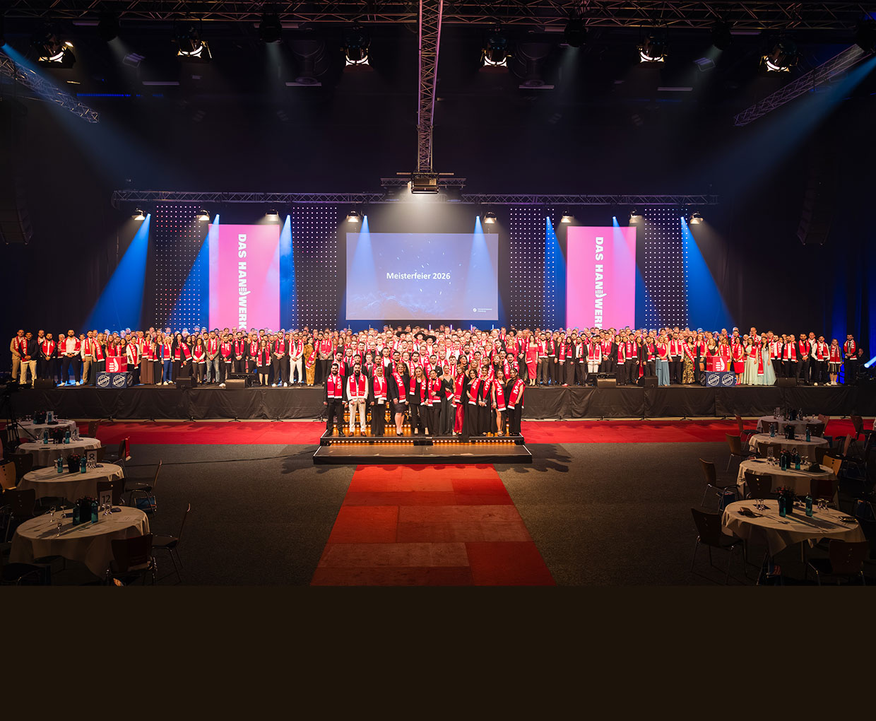 Gruppenbild aller Jungmeister auf der Bühne der EWE-Arena. Überblick. Scheinwerferlicht, roter Teppich vor der Bühne.
